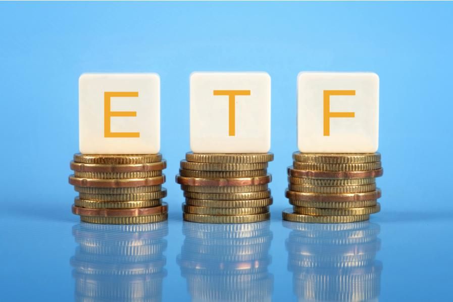 letter blocks reading ETF sit on top of piles of coins